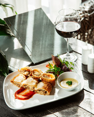 crispy fried crepes stuffed with minced meat and herb garnished with sauce