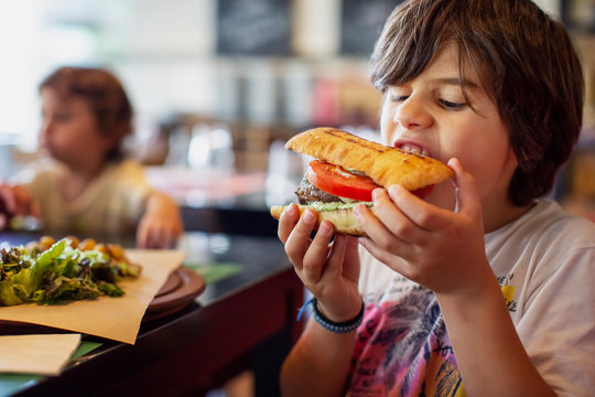 Portrait of a 8 year old boy eating junk food