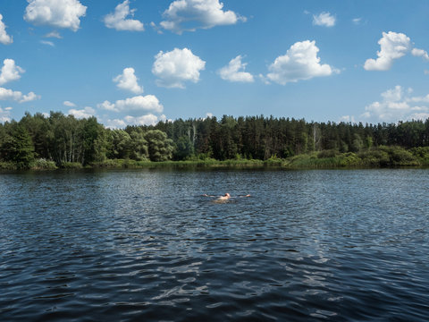 Guy swims in a lake