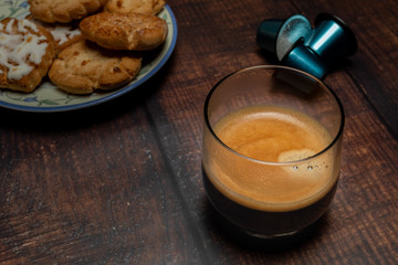 Vaso de café con galletas y cápsulas