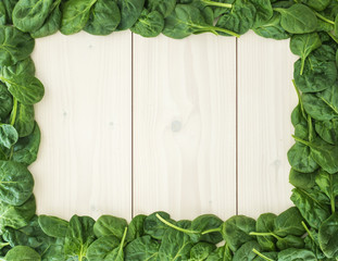 Fresh spinach leaf frame on wooden board