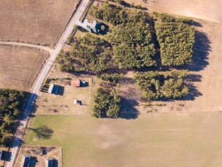 Farm in early spring forest photographed from above