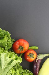 Vegitables on a black background (tomatos, escarole leaves, brinjal or egg plant, chillis, capcicum banana pepper closeup shot with copy space