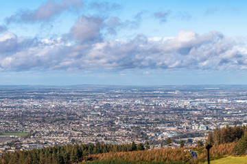 Stunning panoramic view of Dublin city and port from Ticknock, 3rock, Wicklow mountains. Gorse and forest plants in foreground during calm weather