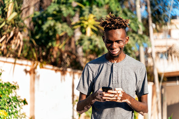 Young man with skin condition vitiligo standing on the street. Blurred background