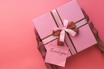 senior women holding pink color gift box