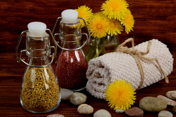 dandelion pollen and bath balls in glass small bottles next to the towel