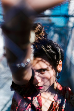 Attractive focused looking Colombian woman with hand on fence