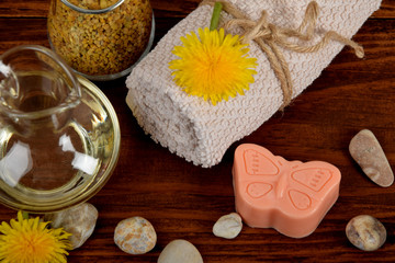 baby soap in the shape of a butterfly, dandelion pollen, body oil next to the towel