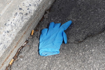 A protection medical glove dropped on the street. The crisis of Covid19 creates pollution outside.
