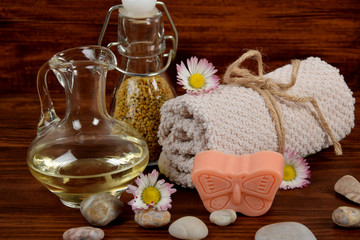 Obraz na płótnie Canvas baby soap in the shape of a butterfly, daisy pollen, body oil and towel