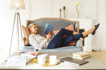 Aged female astrologer lying on a sofa