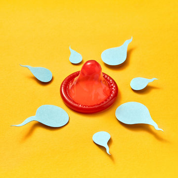 Paper sperm around red condom.