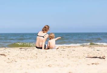 Fototapeta na wymiar Mother and son spending time on sea shore
