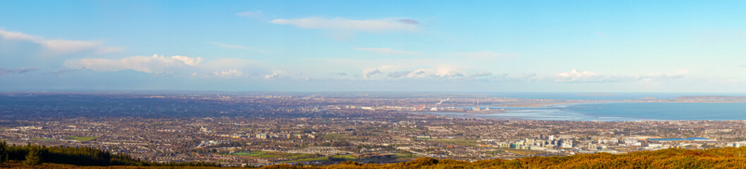 Stunning panoramic view of Dublin city and port from Ticknock, 3rock, Wicklow mountains. Gorse and forest plants in foreground during calm weather