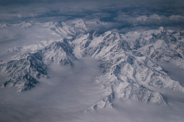 Snowy mountain summits shot from the airplane