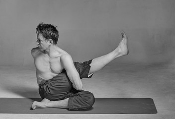 Fototapeta na wymiar Young handsome man performing yoga exercises