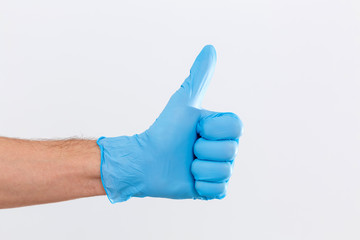 Hand of surgeon in blue medical glove showing Ok sign, isolated on a white background