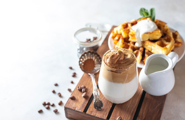Iced frothy drink Dalgona Coffee, trend korean drink latte espresso with coffee. Gray concrete background.