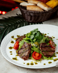grilled beef steak pieces served with vegetables and pesto sauce