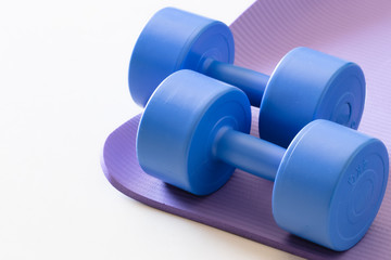 sports ware for gym. Sport concept. Sporting items on purple background or lavender. blue dumbbell on purple mat sport. Space for your text. Sports concept. Sport equipment. Fitness