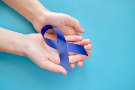 Blue ribbon on on two hands is a symbol of the problem of Stevens-Jones syndrome, colon cancer, problem of hydranencephaly, chronic fatigue syndrome, myalgic encephalomyelitis