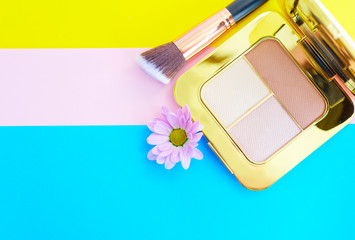 premium makeup brushes and blush pads on a bright colorful background, creative cosmetics flat lay