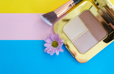 premium makeup brushes and blush pads on a bright colorful background, creative cosmetics flat lay