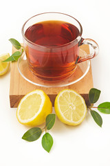 Tea in cup with leaf and lemon on white background