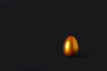 Easter. Nest with golden festive Easter eggs on a black background with copy space, Easter greetings card