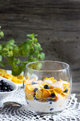 Cornflakes with peaches, blueberries and honey. Healthy breakfast with vitamins.