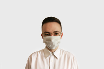 Portrait of a man in a disposable mask and glasses on a white background. Medical worker in a mask and glasses. Isolation 2020. 2020 virus protection.