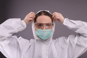 Woman in protective mask put on a protective costume