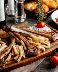 lamb ribs kebab served with french fires over wooden board