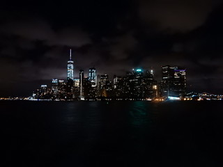 Obraz premium City skyline in New York City, Manhattan bei Nacht von der Fähre aus