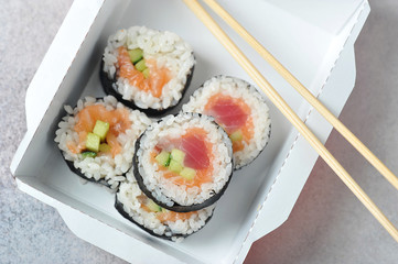 sushi with tuna-in paper packaging with chopsticks