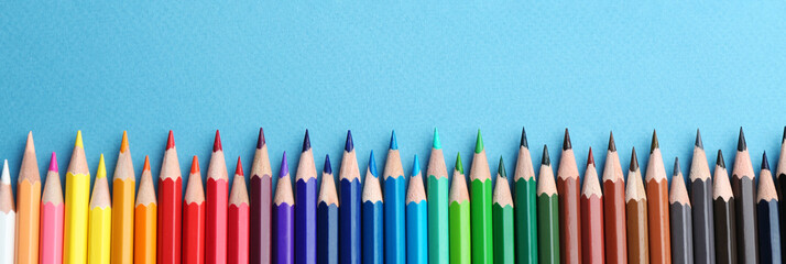 Color pencils on light blue  background, flat lay with space for text. Banner design © New Africa