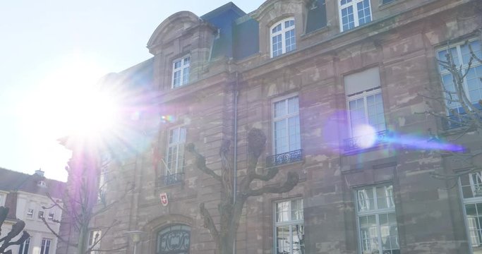 Zoom out from consulate building during Coronavirus confinement to the Switzerland Consulate building in Strasbourg, France - sunlight flare