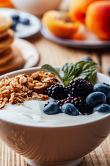 Breakfast bowl with  granola, dried fruits, blackberries, blueberries, yogurt