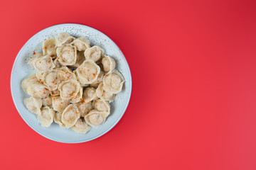 A plate of cooked dumplings in a dish on a trending  background, top view