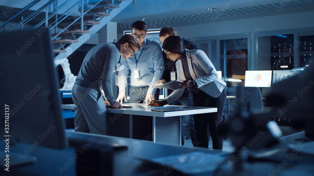 Poster Diverse Team of Electronics Development Engineers Standing at the Desk Working with Documents, Solving Project Problems Late at Night. Specialists Working on Ultra Modern Industrial Design.