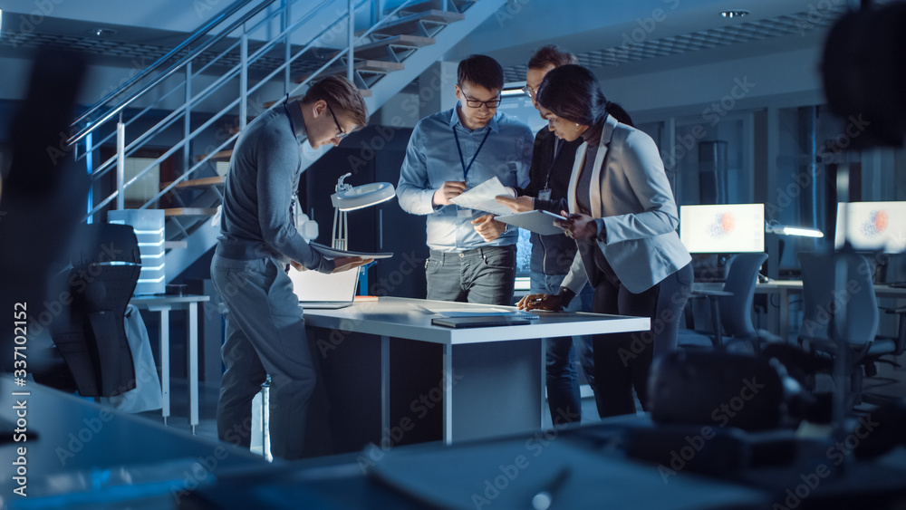 Poster Diverse Team of Electronics Development Engineers Standing at the Desk Successfuly Solving Project Problems Late at Night. Specialists Working on Ultra Modern Industrial Design.