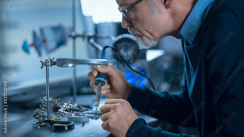 Aufkleber portrait of focused middle aged engineer in glasses working with high precision laser equipment, usi