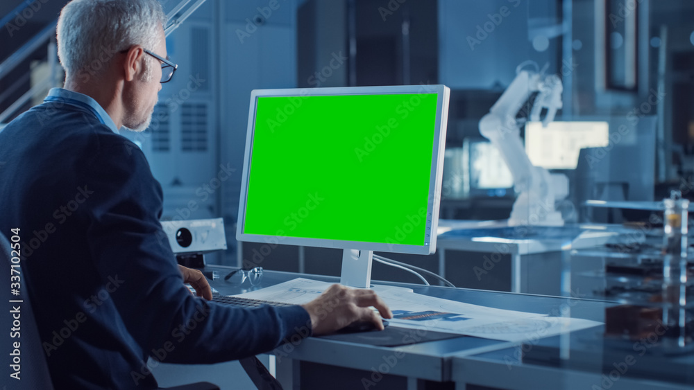 Poster professional heavy industry engineer works on green mock-up screen computer. engineering bureau and 