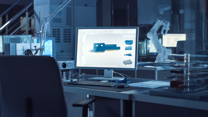  On the Desk Computer With CAD Software and Design of 3D Industrial Machinery Component. In the Background Robot Arm Concept Standing in Heavy the Dark.Industry Engineering Facility.
