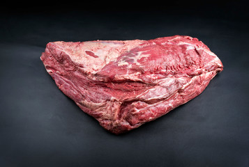 Raw dry aged wagyu beef shoulder clod roast as closeup on black background with copy space