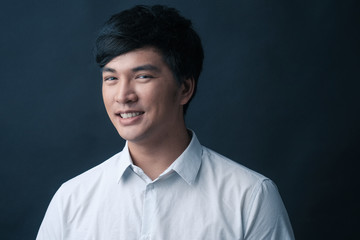 Studio portrait of Asian man on black background