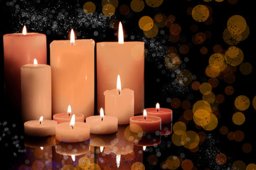 Burning candles on dark background, bokeh effect
