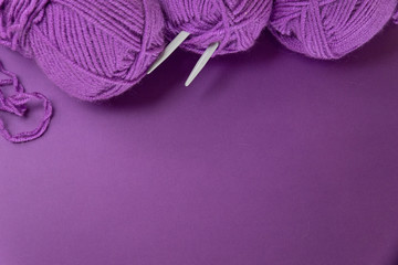 Background with knitting tools and accesories, colorful purple skein yarn, hobby concept, copyspace