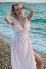 Fototapeta na wymiar Beautiful fashionable blonde woman on the beach by the sea in lingerie
